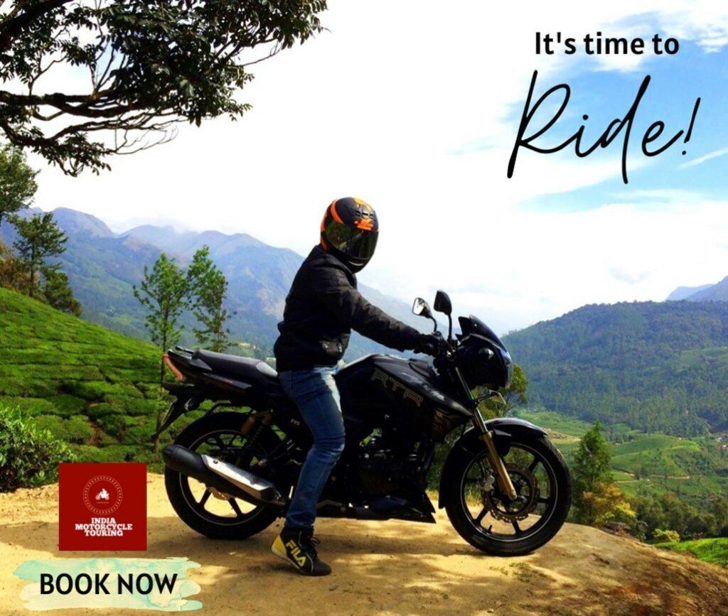 person sitting on a motorbike with mountains in the background